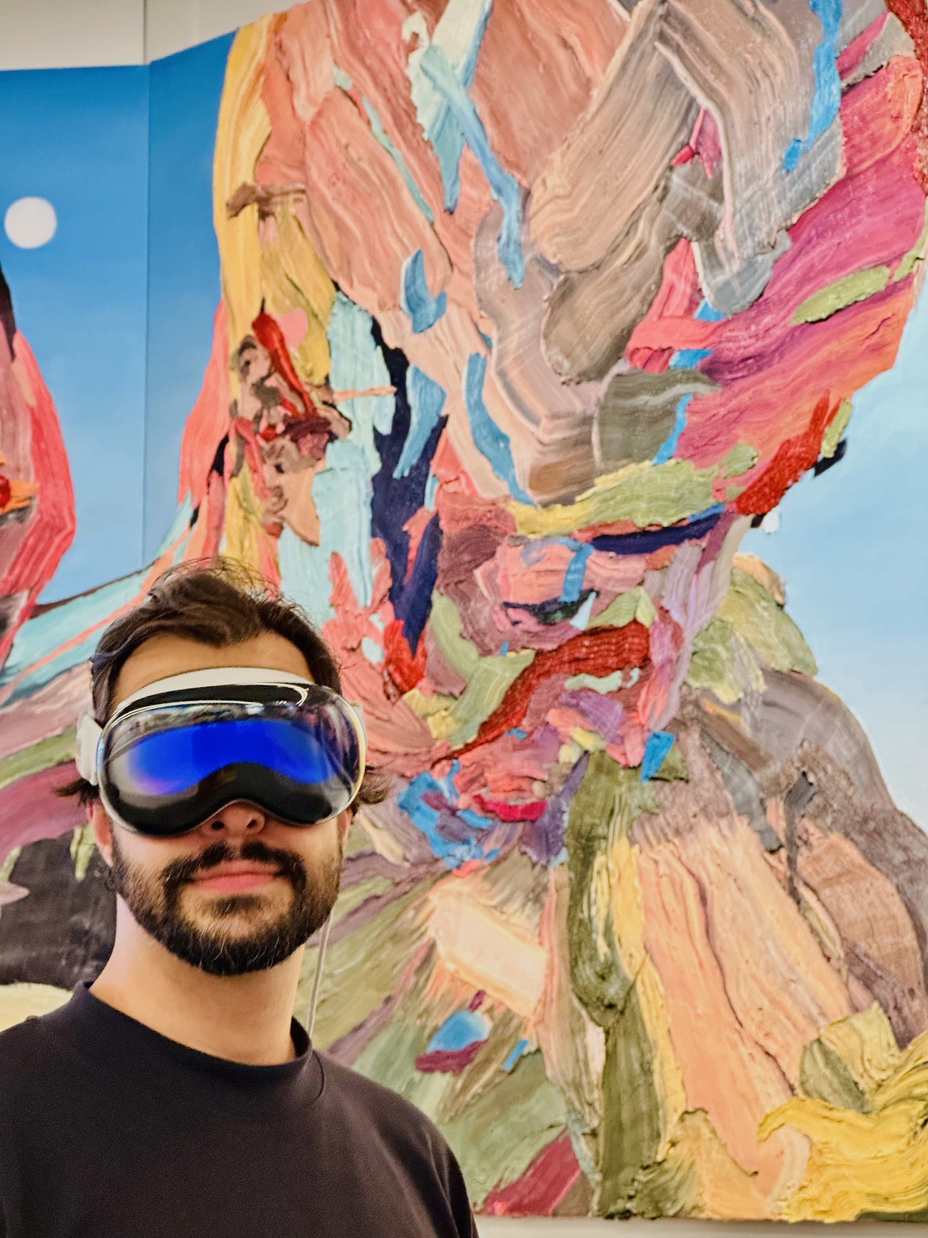 Close-up of a visitor wearing Apple Vision Pro before the painted frieze.